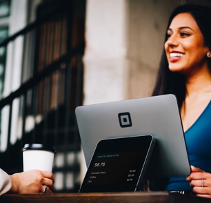 Smiling woman behind a POS tablet