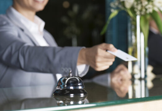 Hotel front desk employee handing over a key