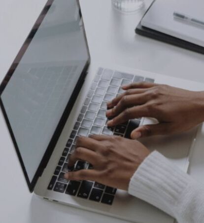 Hands typing on a computer